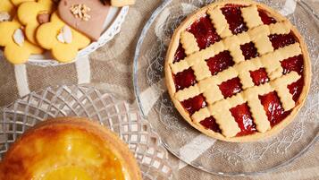 A pie with a lattice crust on a clear glass plate.