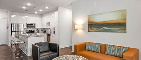 A modern apartment with a kitchen, dining area, and living room.