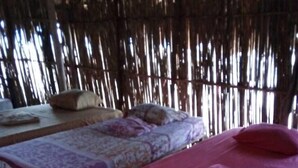 Una habitación con dos camas, una con una colcha estampada y la otra con una colcha roja lisa.