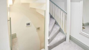A staircase with a light-colored carpet and white walls. - Host & Stay | Threadneedle Cottage (Whitby)