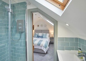 A modern bathroom with a shower, a bathtub, and a skylight. - Host & Stay | Threadneedle Cottage (Whitby)