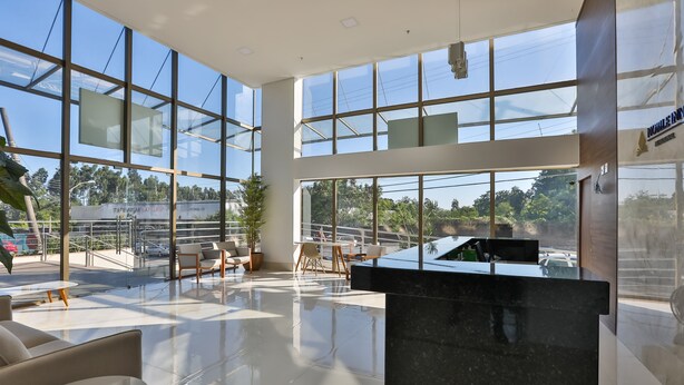 A spacious lobby with large glass windows, a reception desk, and seating areas. - Nobile Inn Meridional Cariacica (Cariacica)