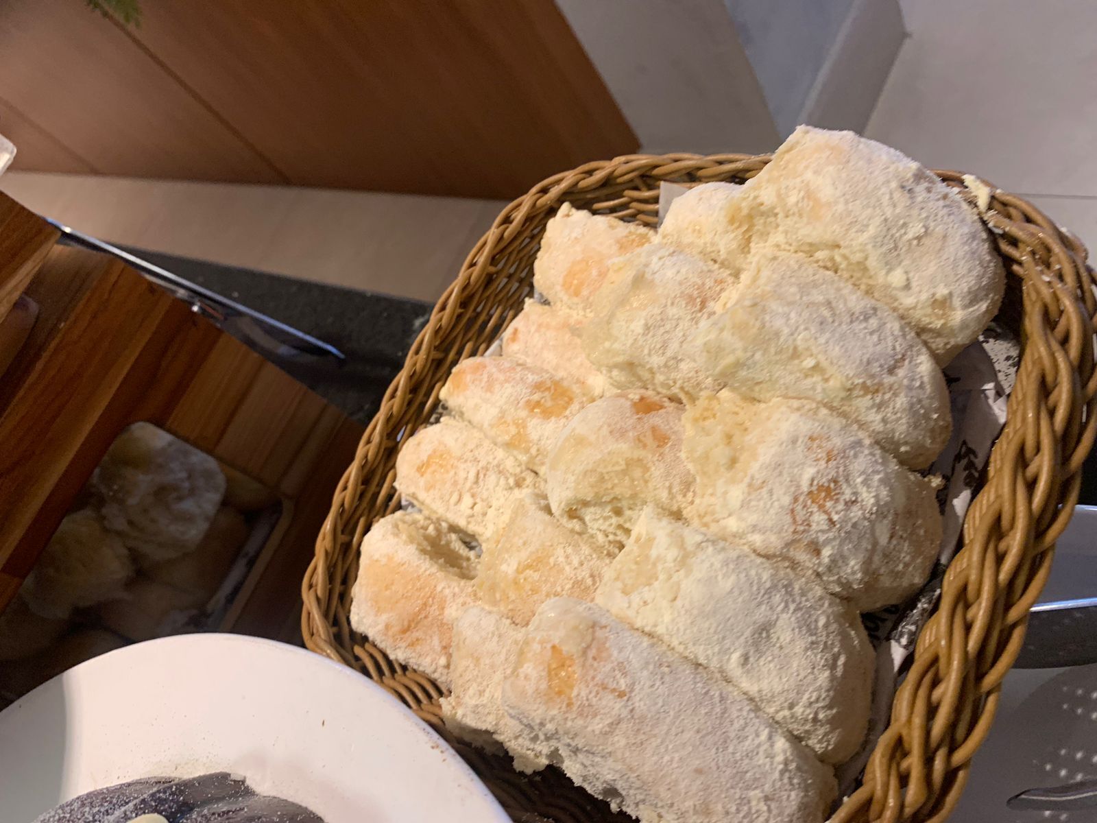 Una cesta con pan recién horneado sobre una mesa.