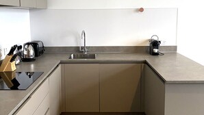 A modern kitchen with a sink, countertop, and cabinets.