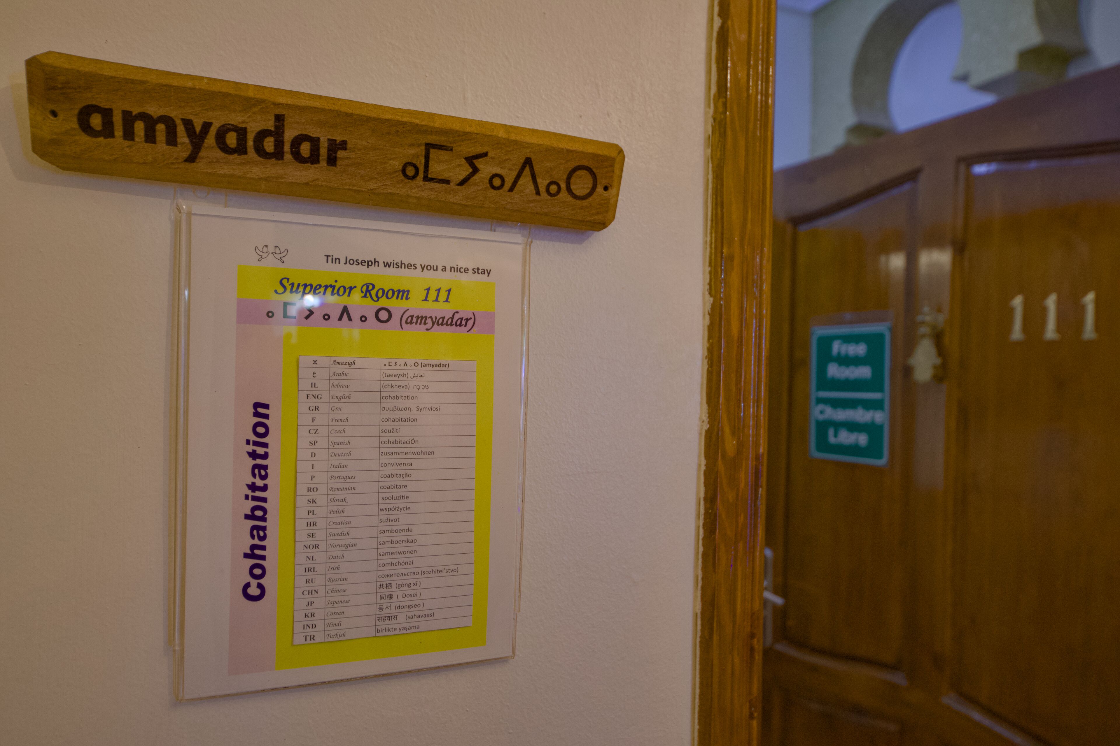 Une plaque en bois portant le nom « amyadar » et une autre plaque indiquant le numéro de chambre « Chambre supérieure 111 ».