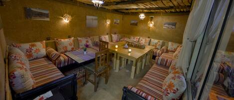 A cozy, rustic dining area with wooden furniture and floral upholstery.