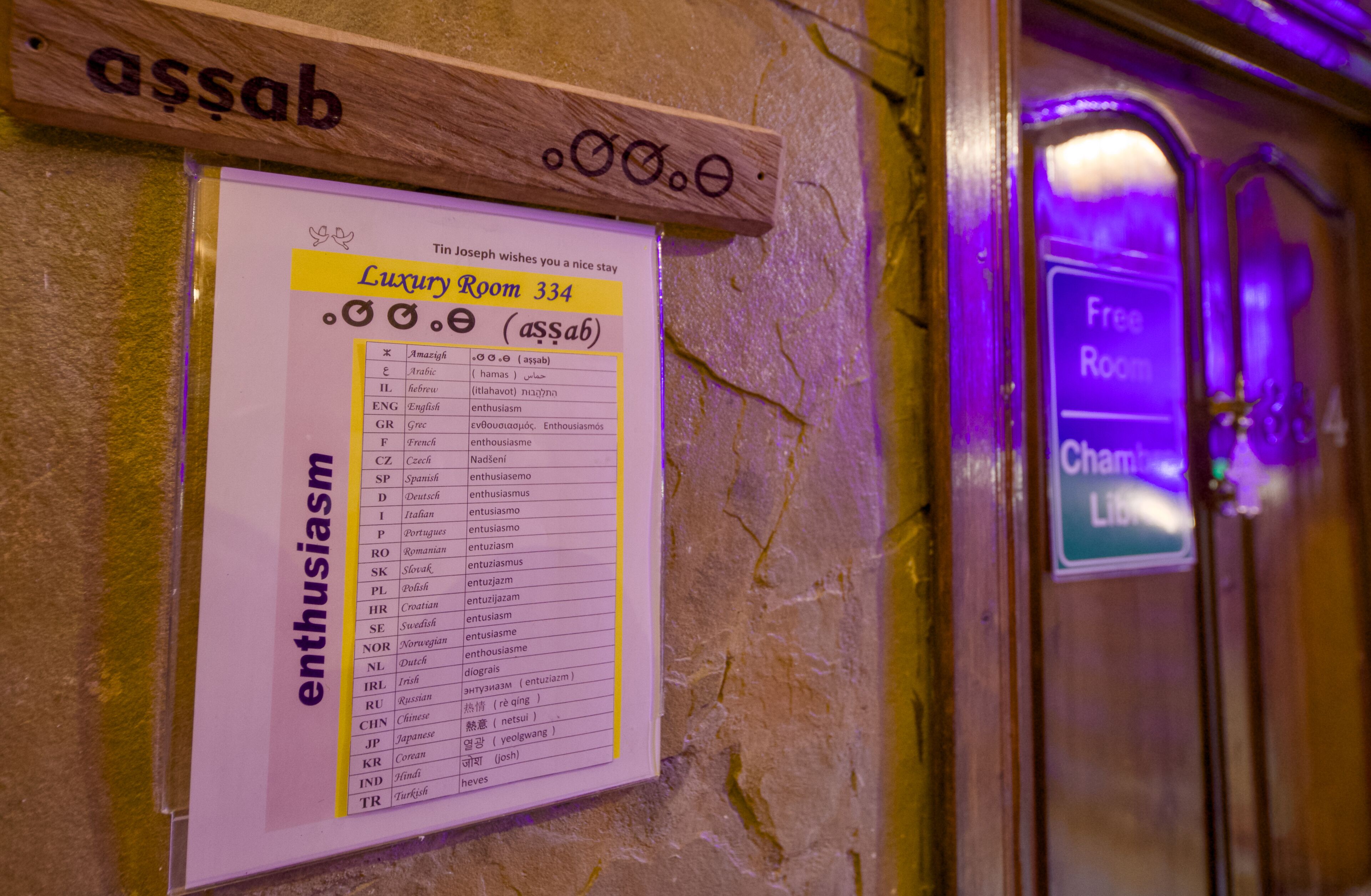 A sign for Luxury Room 334 with a list of languages and the word "enthusiasm" highlighted.