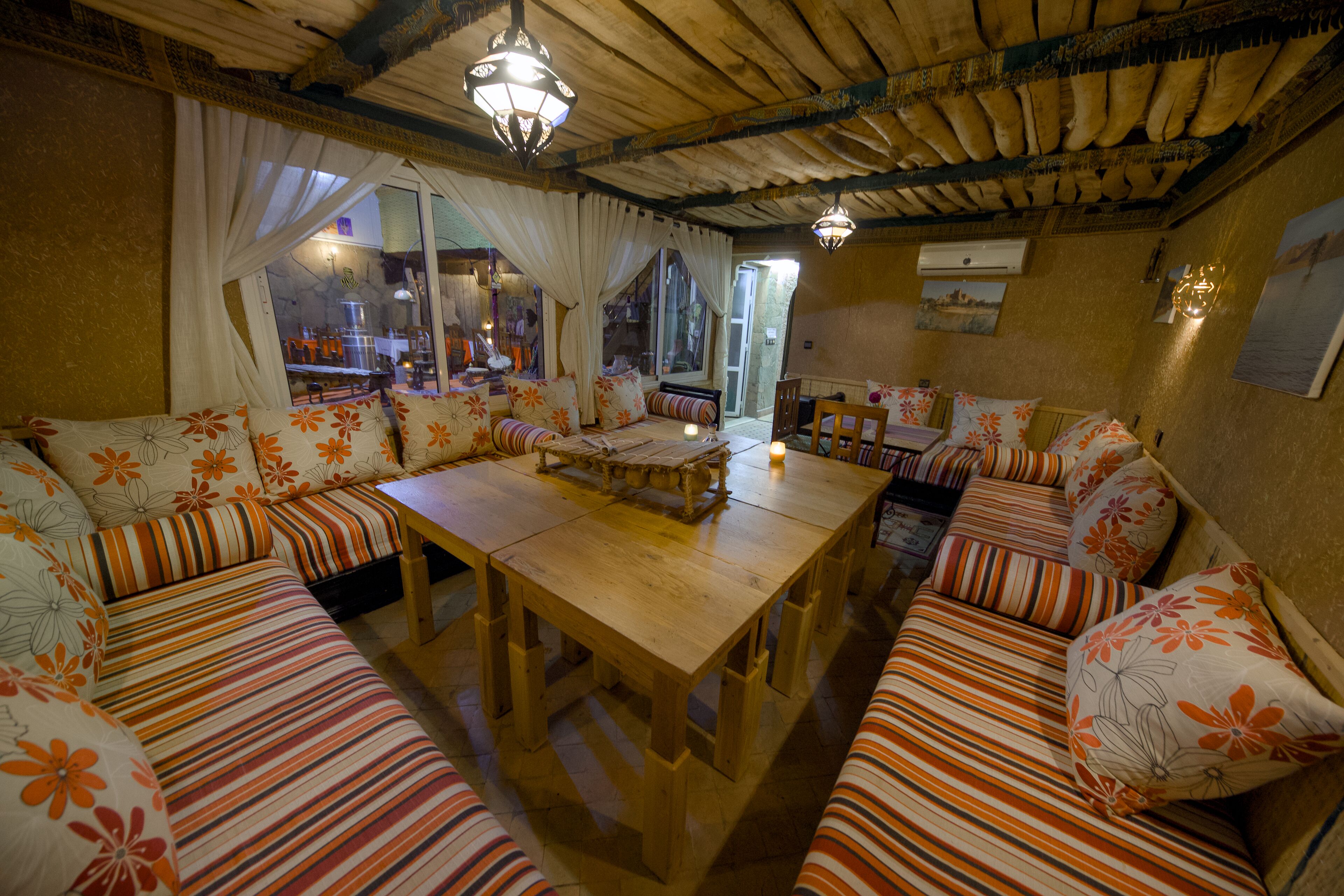 Una habitación acogedora con una mesa de madera y sofás a rayas.