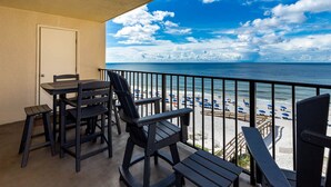 Een balkon met uitzicht op een strand en de oceaan.
