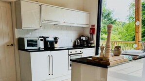 A modern kitchen with white cabinets, a black countertop, and a wooden island.