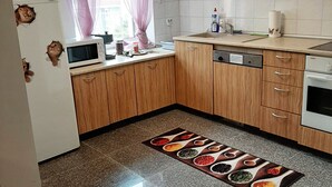 A compact kitchen with wooden cabinets, a microwave, a sink, and a stove.