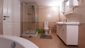 A bathroom with a shower, toilet, sink, and bathtub.