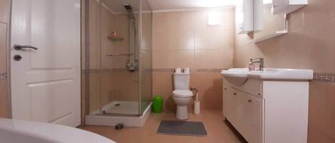 Une salle de bain équipée d’une douche, de toilettes, d’un lavabo et d’une baignoire.