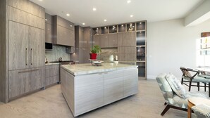 A modern kitchen with a central island, built-in cabinets, and a dining area with a table and chairs. - Landmark 517 - 2 Bedroom Diamond (Vail)