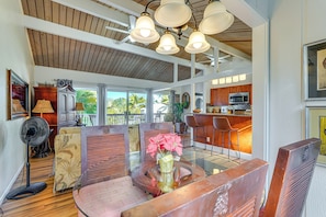 Cozy living area with a high ceiling, glass dining table, and comfortable seating.