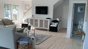 En moderne stue med sofa, fjernsyn og en kurveskål.