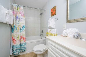 Un baño con bañera, inodoro y lavamanos.