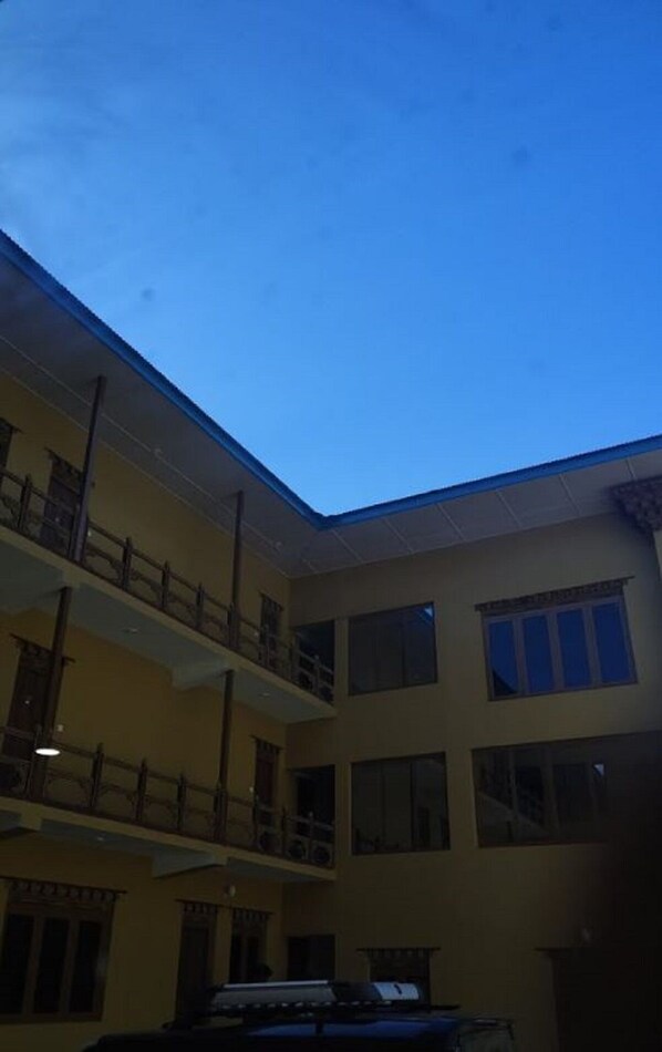 A multi-story building with a flat roof and large windows.
