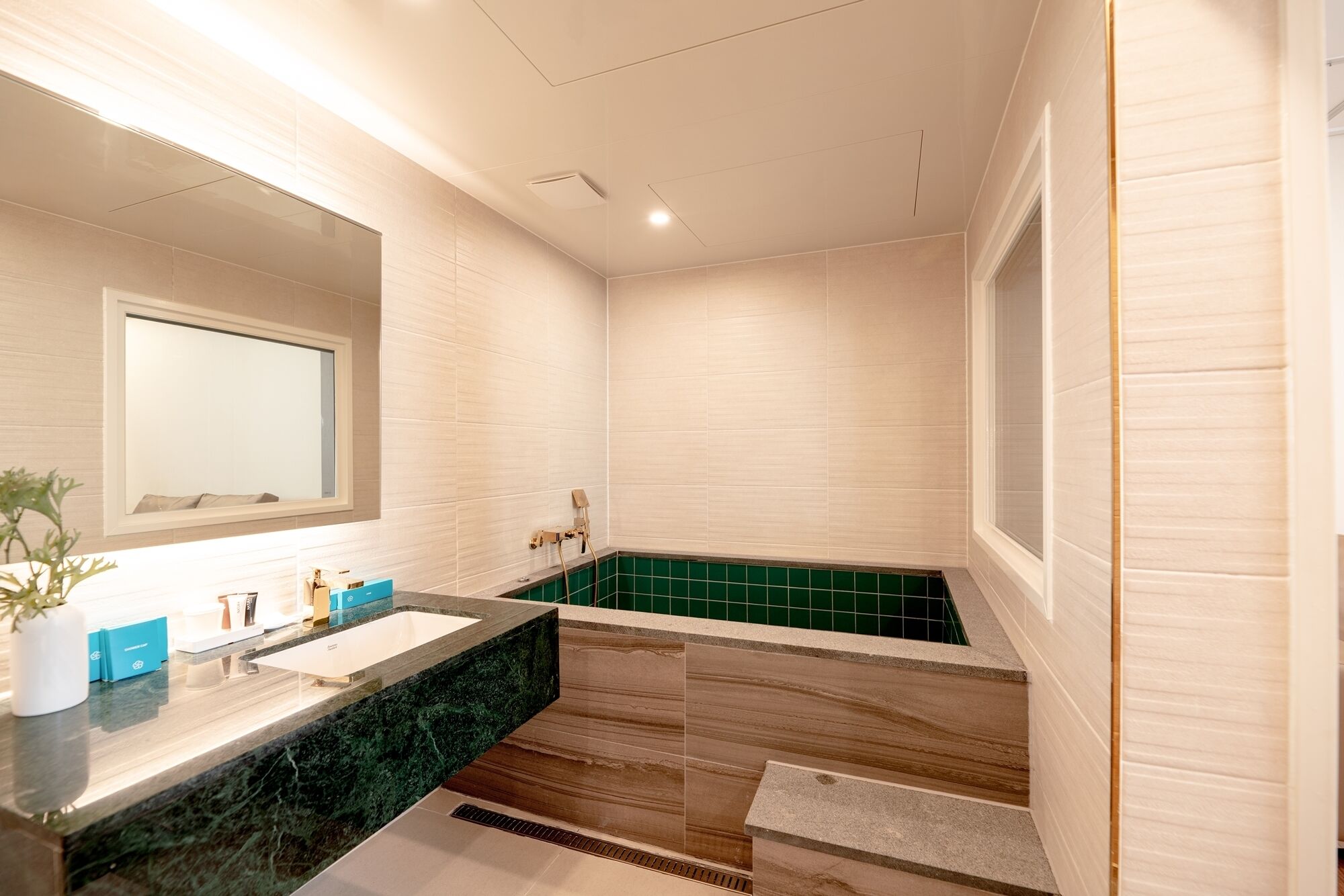 Un bagno moderno con un ampio specchio, un lavandino e una vasca da bagno.