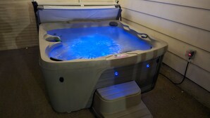 A hot tub with a built-in seat and a step for easy access. - Five Bedrooms and a Great Location (Sioux Falls)