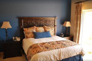 Ein Schlafzimmer mit einem großen Bett, zwei Nachttischen und einem Beistelltisch.