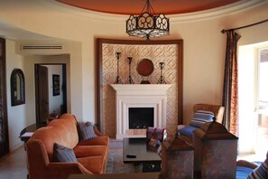 Ein Wohnzimmer mit Kamin, zwei Sofas, einem Couchtisch und einer Wand mit Muster.