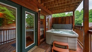 A wooden deck with a hot tub and a small wooden bench. - Best Location/HotTub/Resort Pool/Game Rm/Fast WiFi
Dollywood 2 minutes away! (Sevierville)