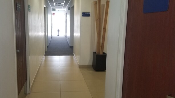 A hotel hallway with a tiled floor, wooden doors, and a sign indicating the PC/Internet room. - Hotel Tecnologico Norte (Chihuahua)