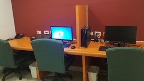 A workspace with two computers, a desk, chairs, and a trash bin. - Hotel Tecnologico Norte (Chihuahua)