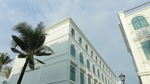 Um edifício branco com várias janelas e uma varanda.