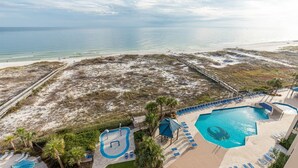 A resort with a large pool, beach access, and a view of the ocean.