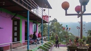 A building with a purple exterior, a balcony, and a staircase leading to the entrance. - Nagarkot Community Homestay (Mahamanjushree Nagarkot)