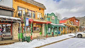 Eine verschneite Straße mit bunten Häusern, darunter ein Restaurant und eine Pizzeria.