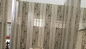 A bathroom with a toilet, sink, and striped wallpaper. - Atozee Airport villa (Seeduwa - Katunayake)