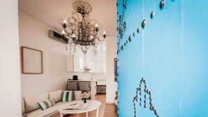 Un salon moderne avec un canapé, une table basse et un lustre.