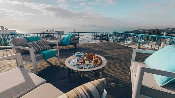 Une terrasse avec des sièges et une table préparée pour le thé.