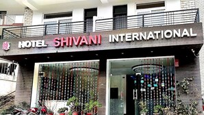 The exterior of Hotel Shivani International with a modern design, featuring a prominent entrance and a balcony with railings. - Hotel Shivani International (Dharamshala)