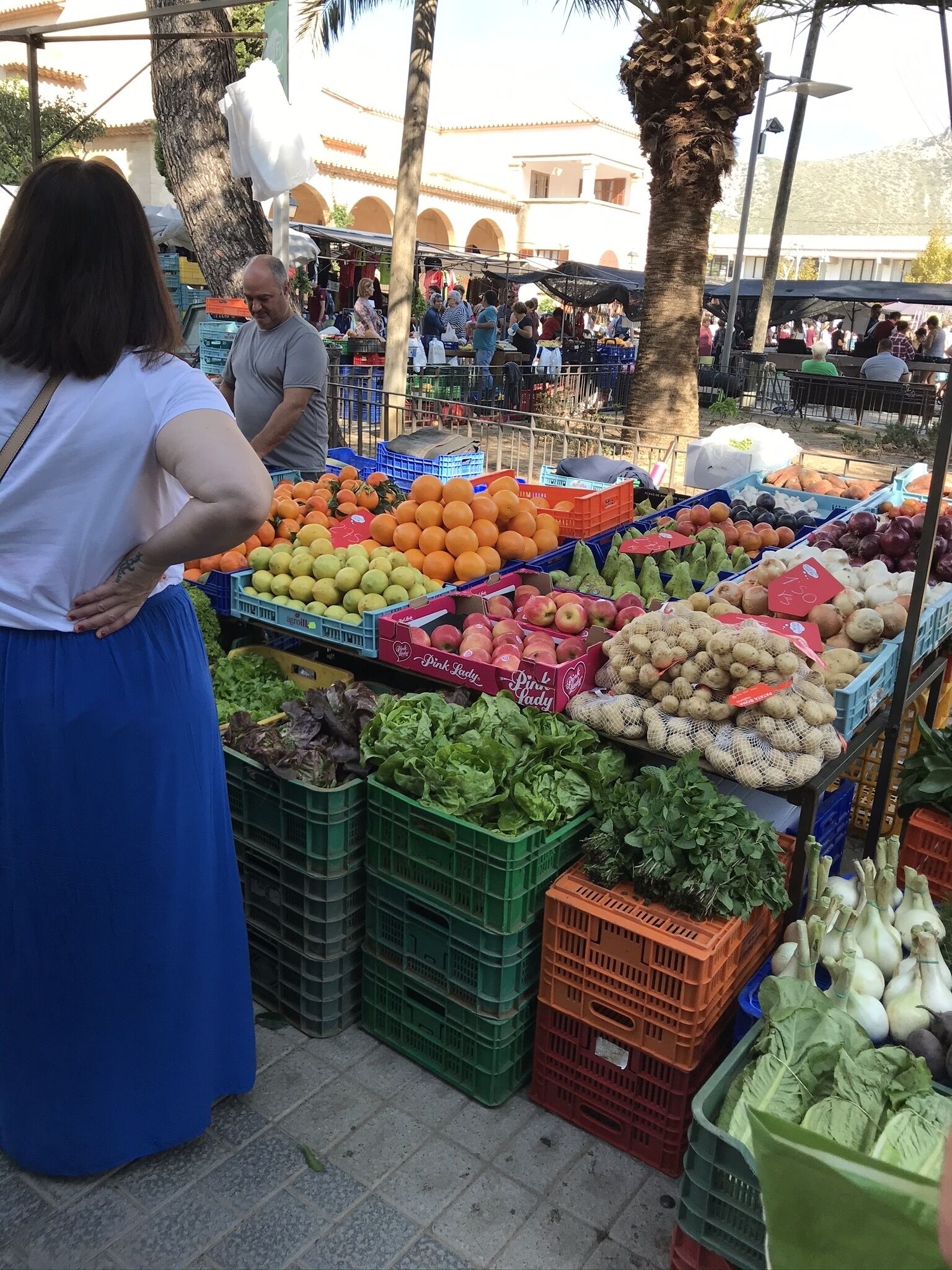 A market stall with various fruits and vegetables displayed in crates.