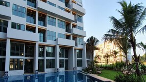 A modern hotel with a large pool area, multiple balconies, and lush greenery. - Atom Phuket Hotel (Sa Khu)