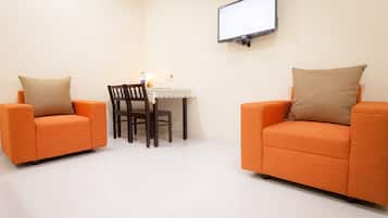 Deluxe tweepersoonskamer | Woonruimte | Een 32-inch ledtelevisie met kabelzenders en een televisie