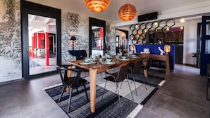 A modern dining area with a wooden table set for six, black chairs, and a patterned rug. - Villa Genevieve | Creole Elegance Above Gustavia (Lurín)