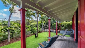 A covered outdoor area with two rocking chairs, a small table, and a large planter. - Villa Genevieve | Creole Elegance Above Gustavia (Lurín)