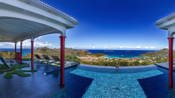 A infinity pool with a view of the ocean and a coastal town. - Villa Genevieve | Creole Elegance Above Gustavia (Lurín)