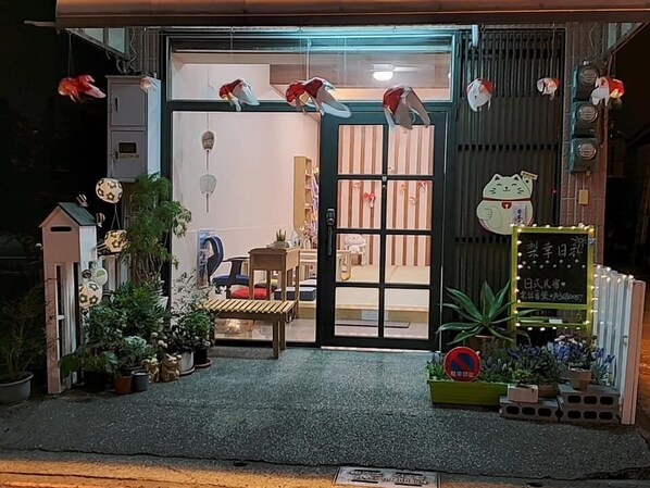 A storefront with a large glass door, potted plants, and various decorative items outside. - Good days in Liko (Kaohsiung)
