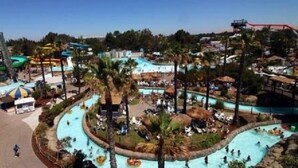 A water park with multiple pools and slides, surrounded by palm trees and shaded areas. - Residence Inn by Marriott Walnut Creek (Walnut Creek)