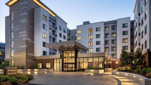 A modern hotel entrance with a well-lit facade, large windows, and a landscaped courtyard. - Residence Inn by Marriott Walnut Creek (Walnut Creek)