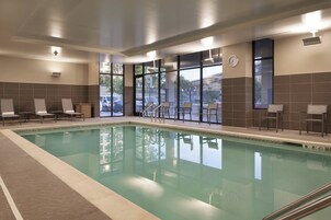 Una piscina con sillas de descanso y vistas al exterior.