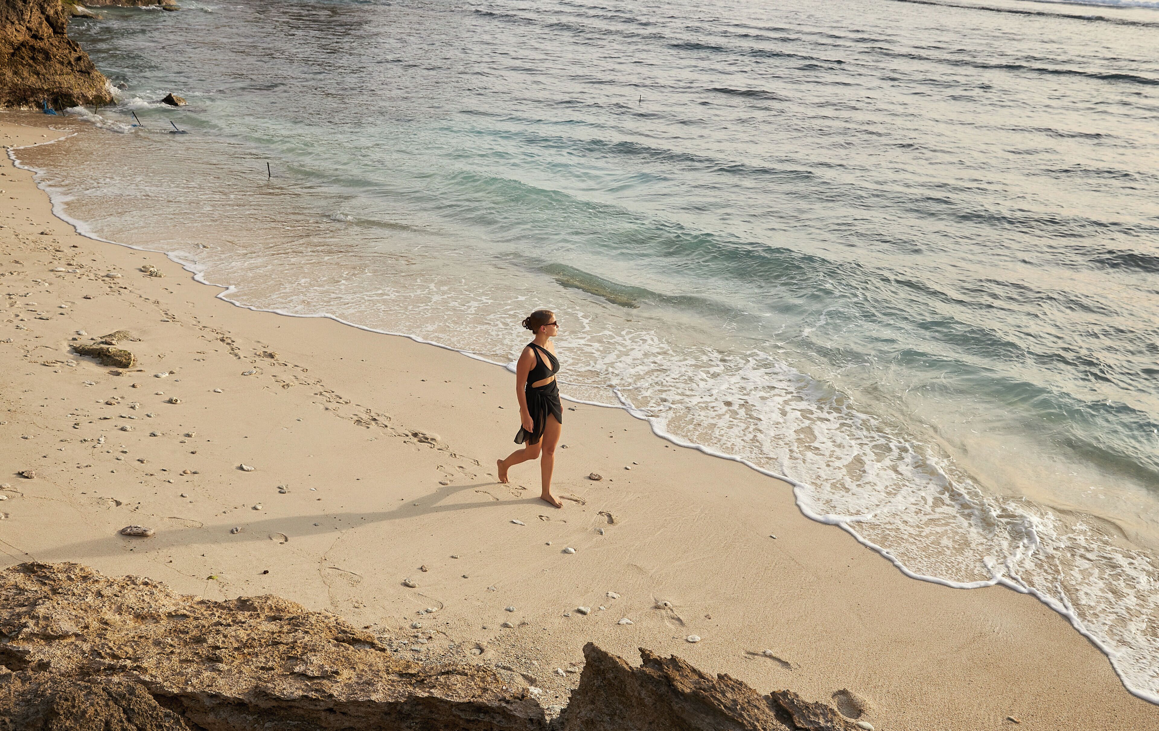 A sandy beach with footprints leading to the water.