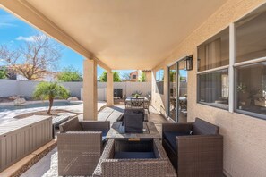 An outdoor patio with wicker furniture, a pool, and a covered area with large windows. - BRAND NEW Spacious 5BR with Heated Pool & Hot Tub & Mini Putt (Mesa)