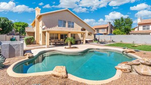 A house with a swimming pool, patio furniture, and a well-maintained lawn. - Brand New Luxury 5BR | Pool, Hot Tub & Mini Golf (Mesa)